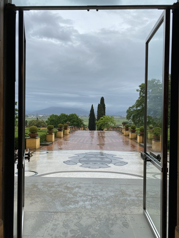 Villa Castelletti - porta che si apre su salita verso la villa, cipressi e altri alberi.
