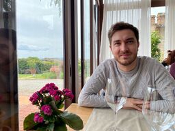 Impruneta - ristorante Diadema: Lorenzo seduto al tavolo con bicchieri di vino e piantina fiorita.