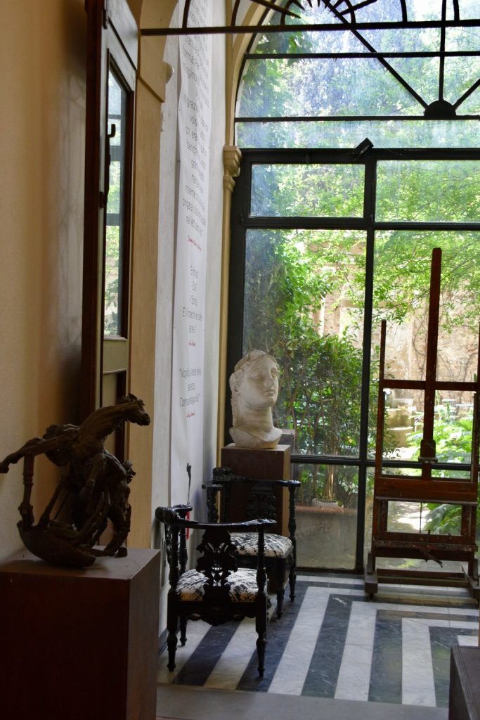 Palazzo Leopardi - opere d'arte e finestra che dà sul piccolo giardino verdeggiante.